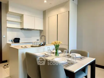 Modern kitchen with dining area featuring sleek cabinetry and elegant table setting.