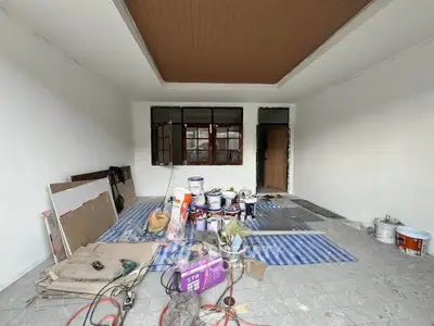 Spacious room under renovation with paint supplies and tools, ideal for customization.