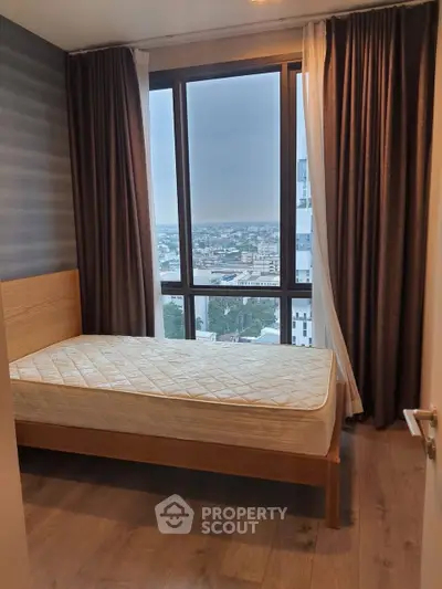 Cozy bedroom with large window offering stunning city view