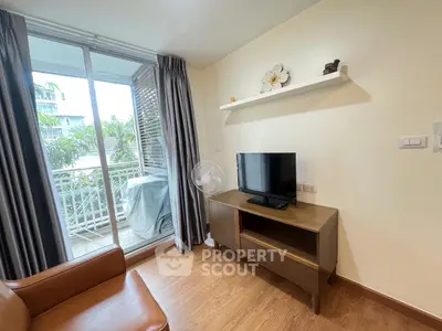 Cozy living room with balcony access and modern furnishings in a stylish apartment.