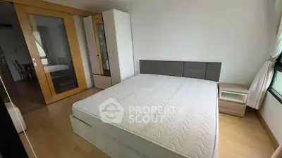 Spacious bedroom with modern furnishings and large windows for natural light.