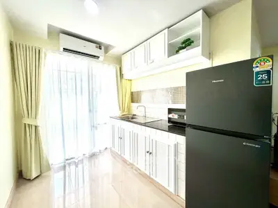 Bright modern kitchen with sleek cabinets and large fridge, perfect for culinary enthusiasts.