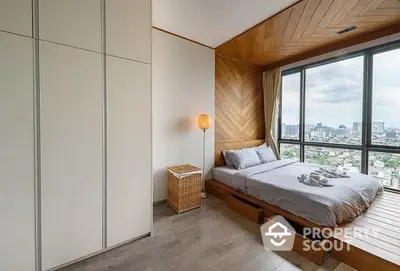 Modern bedroom with wooden accent wall and panoramic city view through large window, offering a serene urban retreat.