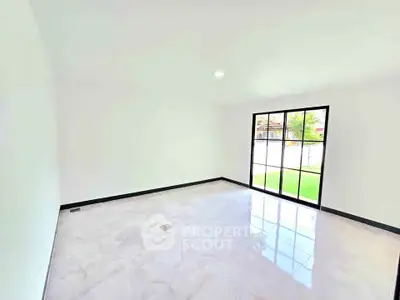 Spacious empty room with large window and garden view, perfect for customization.