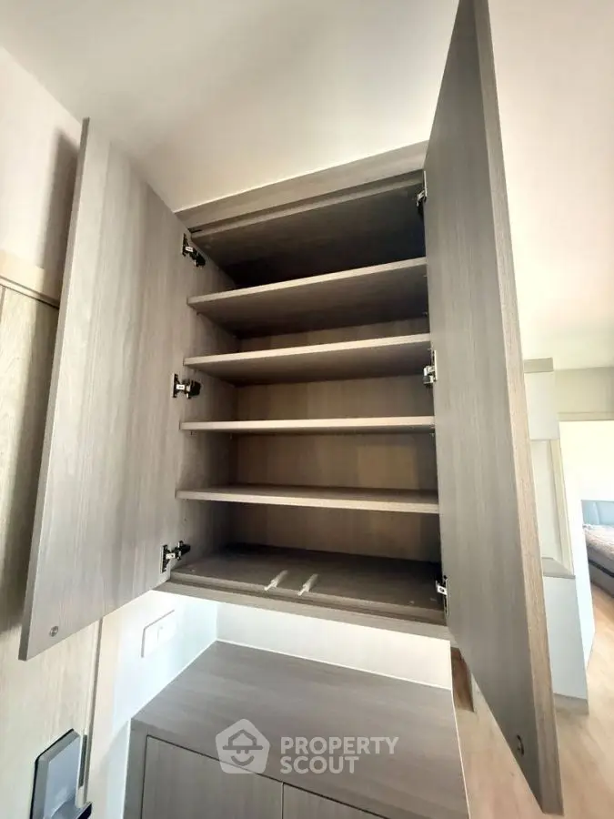 Spacious wooden storage cabinet with open shelves in modern home interior.