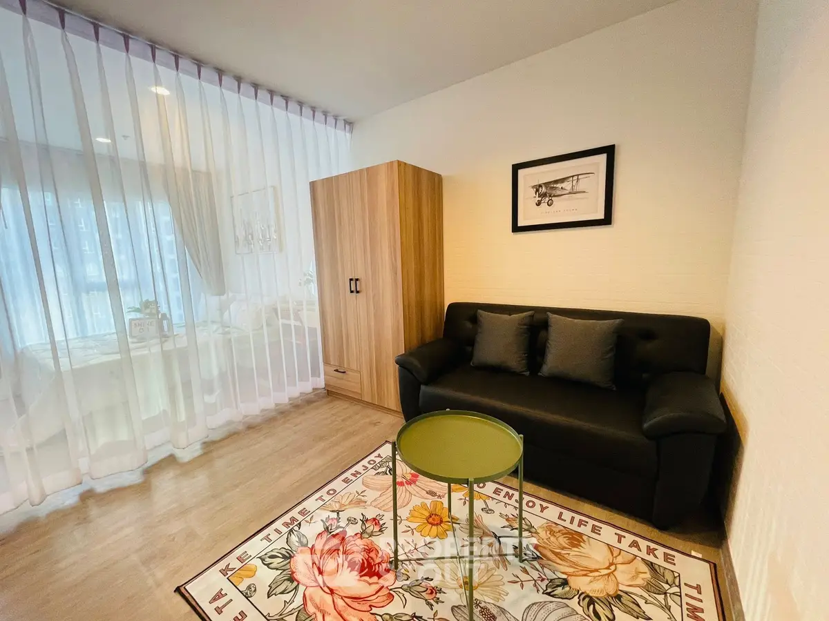 Chic living room with modern decor, cozy sofa, and floral rug in a stylish apartment.