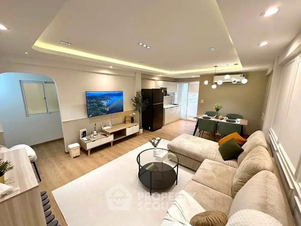 Spacious modern living room with open kitchen, stylish decor, and cozy seating area.