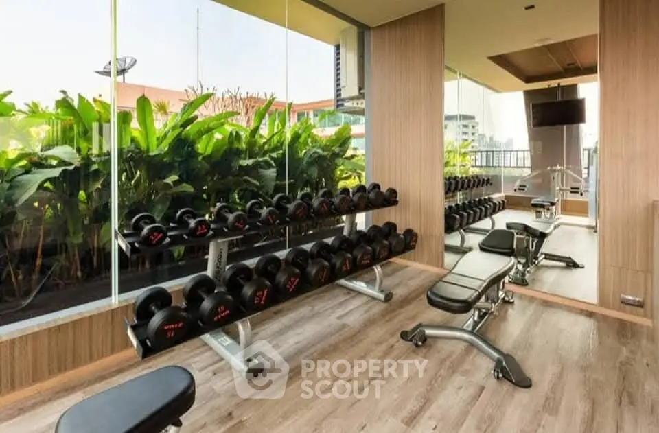 Modern gym with lush greenery view and state-of-the-art equipment.