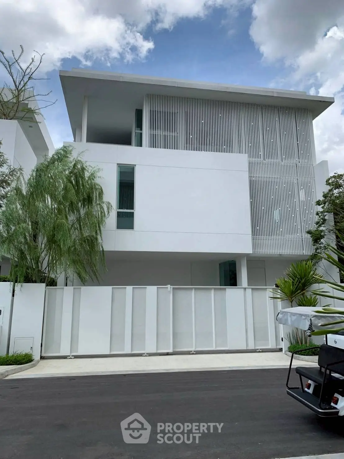 Modern white minimalist house with sleek design and lush greenery