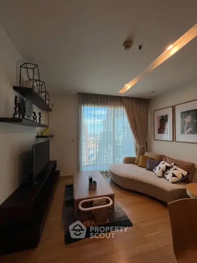 Stylish living room with modern decor and large window offering natural light.