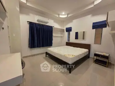 Spacious bedroom with modern design, featuring a comfortable bed, air conditioning, and stylish curtains.