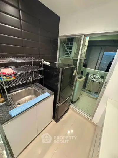 Modern kitchen with sleek appliances and laundry area in stylish apartment.