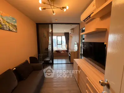 Modern living room with open view to bedroom, featuring stylish furniture and cityscape view.