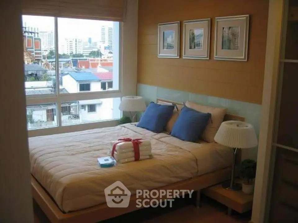 Cozy bedroom with city view, featuring a comfortable bed and stylish decor.