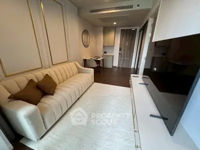 Modern living room with elegant sofa and large TV, featuring stylish decor and cozy ambiance.