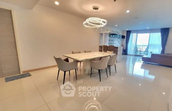 Spacious modern dining area with elegant chandelier and open living room view.
