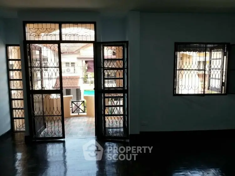 Spacious living room with large windows and balcony access in a modern apartment.