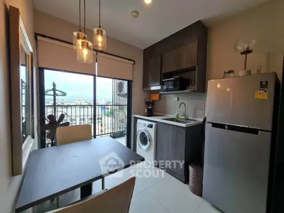 Modern kitchen with washing machine and fridge, featuring open layout and city view.