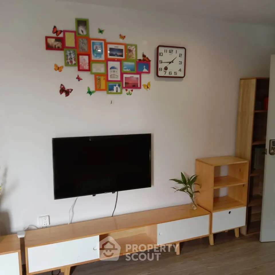 Charming living room with modern TV setup and colorful wall decor, perfect for cozy family gatherings.