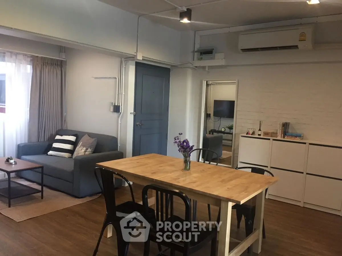 Chic modern living room with cozy seating and stylish dining area, perfect for urban living.