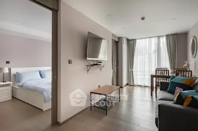 Modern open-plan living room with cozy seating and wall-mounted TV, adjacent to a stylish bedroom.