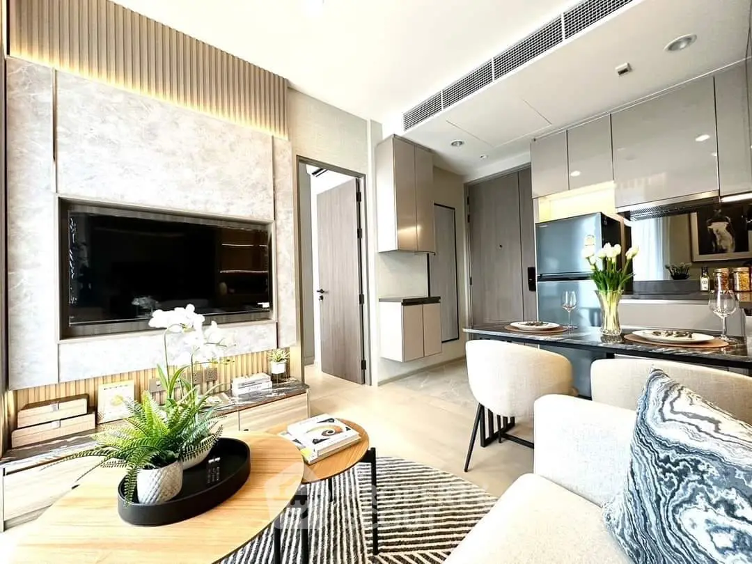 Modern living room with open kitchen, stylish decor, and natural light in a contemporary apartment.