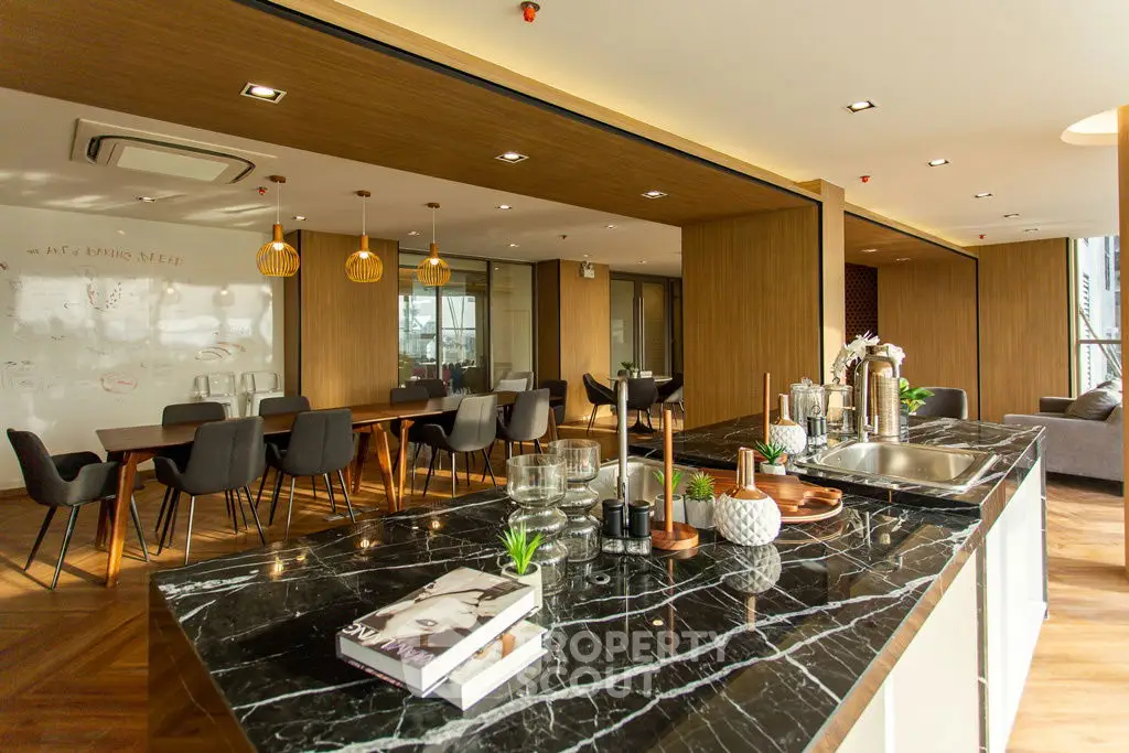 Luxurious open-plan kitchen and dining area with elegant marble countertops and modern decor.
