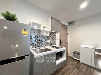 Modern kitchen with sleek cabinetry and stainless steel appliances in a stylish apartment.