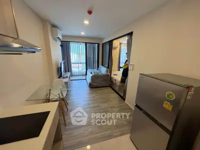 Modern apartment interior with open layout kitchen and cozy living area, featuring stylish furniture and natural light.