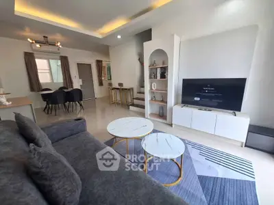 Modern living room with stylish decor and open layout, featuring a cozy sofa and sleek TV unit.