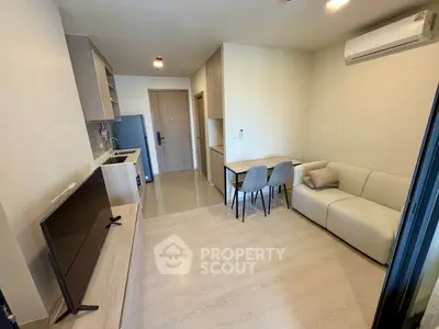 Modern living room with sleek furniture and open kitchen layout in a cozy apartment.