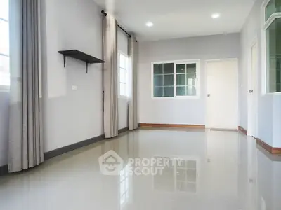 Spacious empty room with large windows and glossy tiled floor, perfect for customization.
