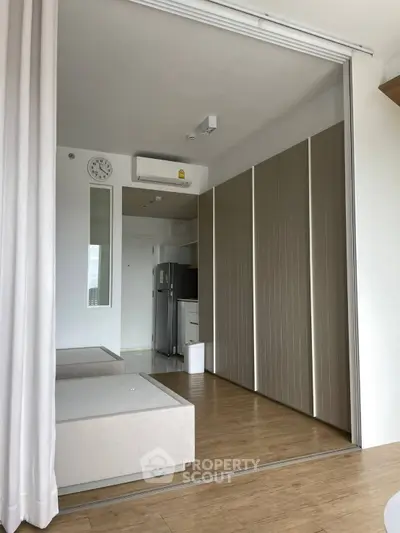 Modern studio apartment with sleek design and built-in storage solutions.