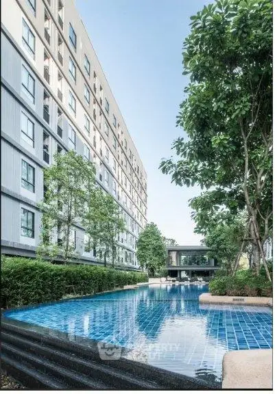 Modern apartment building with a luxurious outdoor pool and lush greenery, perfect for urban living.