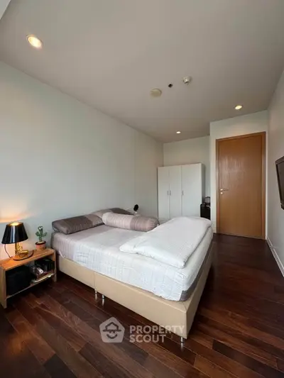 Modern bedroom with wooden flooring and minimalist decor