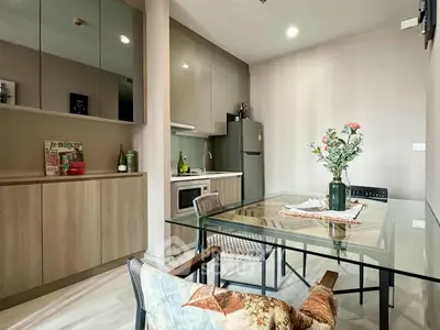 Modern kitchen with sleek cabinets and glass dining table in cozy apartment