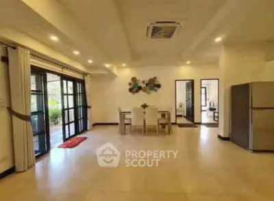 Spacious open-plan living area with modern decor and large windows.