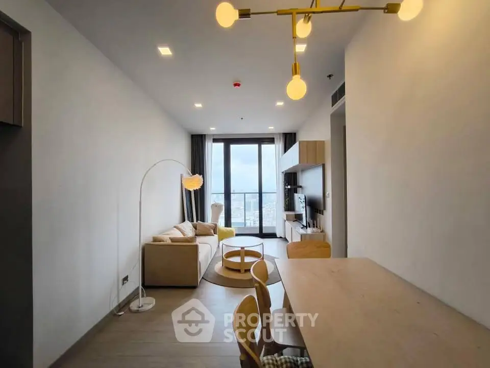 Modern living room with stylish decor and city view, featuring a cozy sofa and elegant lighting.