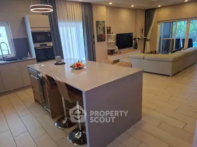 Luxurious open-plan kitchen and living room with modern decor and island seating.