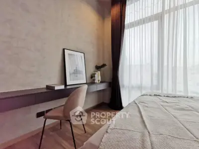 Elegant bedroom with modern decor and large window offering natural light