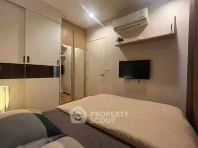 Cozy bedroom with modern decor, featuring a wall-mounted TV and air conditioning for comfort.