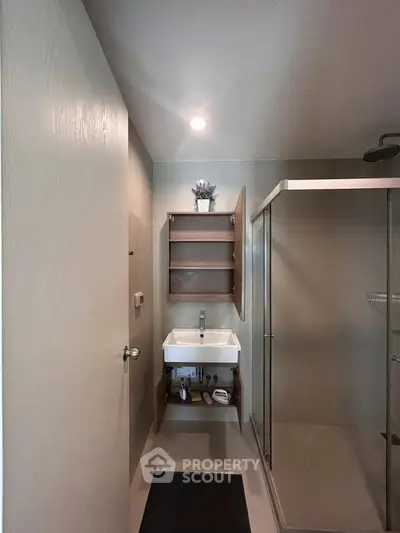 Modern bathroom with sleek shower and stylish sink in a contemporary apartment.