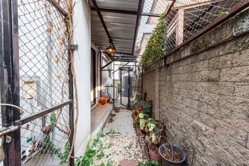 Charming narrow outdoor corridor with rustic decor and greenery