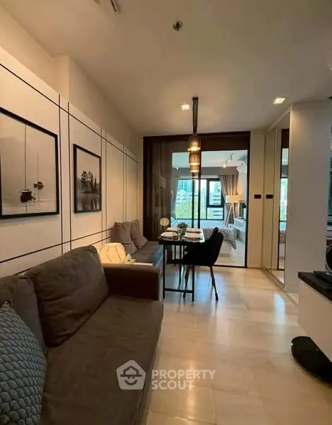 Modern living room with stylish decor and open layout, featuring cozy seating and elegant lighting.