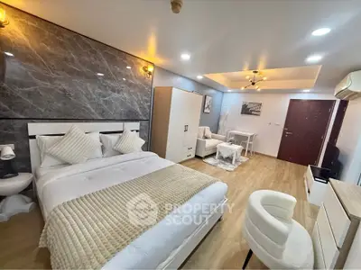 Luxurious modern bedroom with elegant decor and cozy seating area