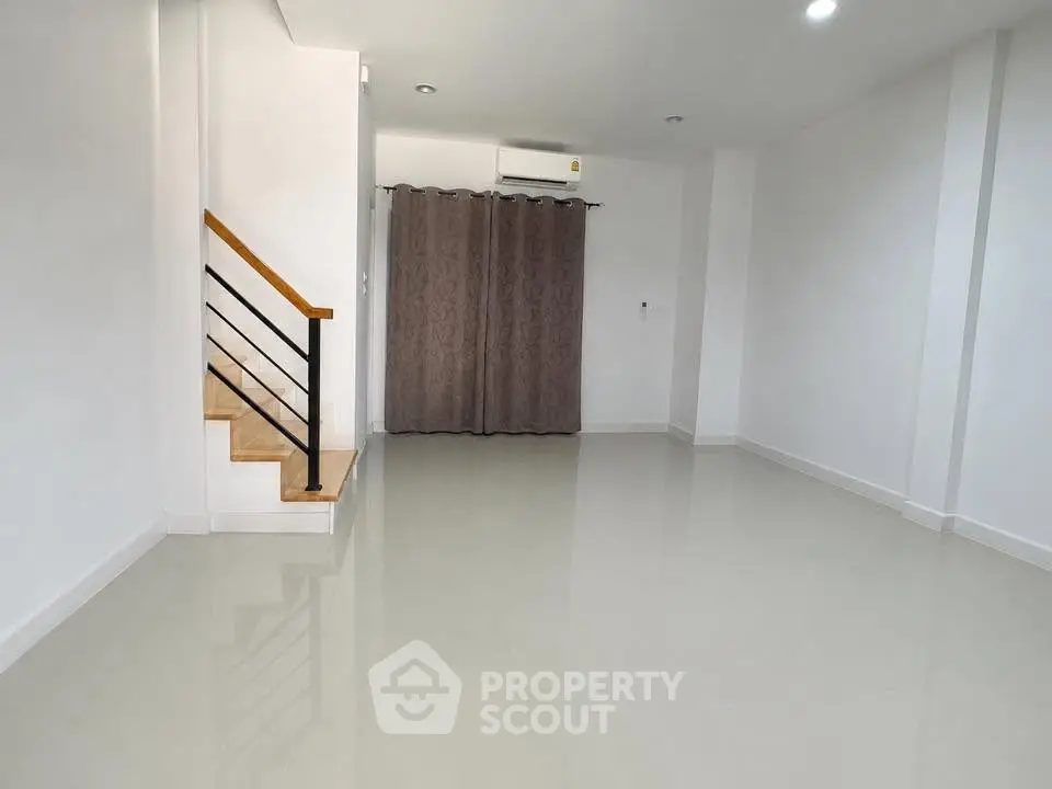 Spacious modern living room with sleek staircase and air conditioning