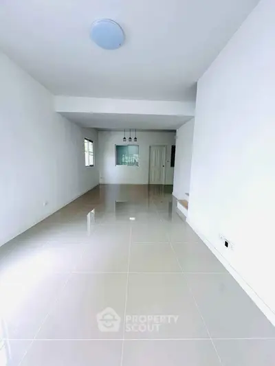 Spacious modern living room with glossy tiled floors and minimalist design.