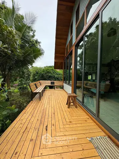 Stunning wooden deck with lush garden views and modern glass facade