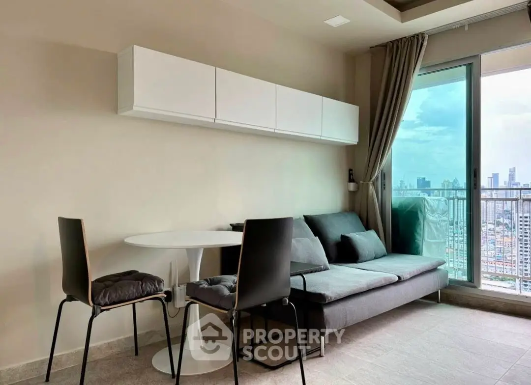 Modern living room with city view, featuring sleek furniture and large windows for natural light.