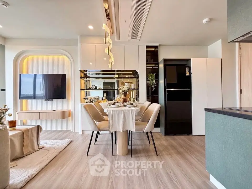 Modern open-plan living and dining area with stylish decor and elegant lighting.